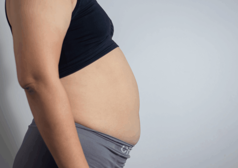 Bauch einer Frau nach der Geburt in der Seitenansicht
